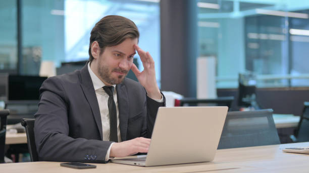 istock Angry Businessman Working on Laptop in Frustration 1421430683