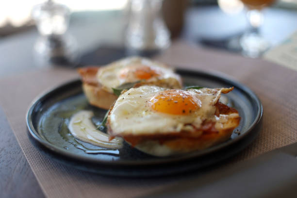 istock Fried eggs on french baguette, ham and bacon for breakfast 1421432074