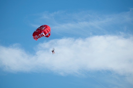 Ocean City, USA - September 3, 2022. Two people parasail gliding through sky, Ocean City, New Jersey, USA