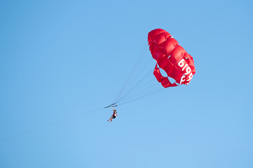 Double ski paragliding in the mountains in winter on blue sky background.