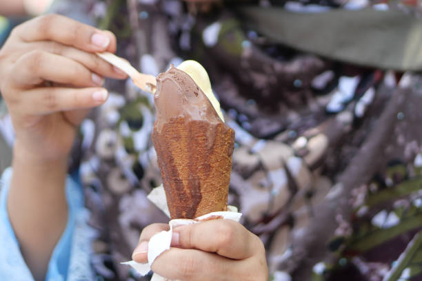 istock young women eating chocolate flavor ice cream 1421436775