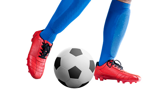 Football player man in a blue jersey kicking the ball posing isolated over white background