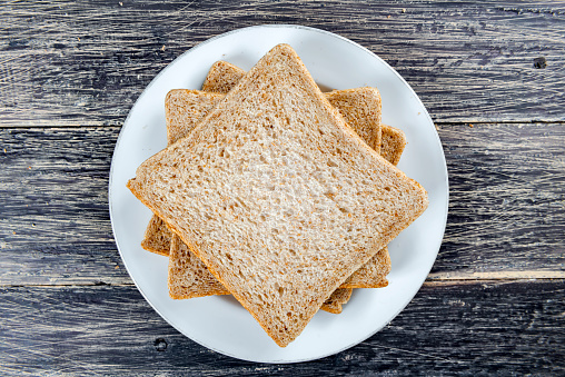 Sliced bread on the plate on wooden background