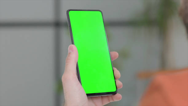 istock Close Up of Young Man Using Smartphone with Green Screen 1421450125