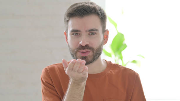 istock Young Man giving Flying Kiss by Hands 1421452633