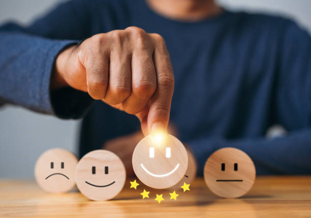 istock Hand man chooses a smiley face on wood block cube. Best excellent business services rating customer experience. Satisfaction survey concept. 5 Star Satisfaction. Picking best service concept. 1421453607