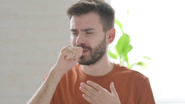 istock Young Man Coughing and Feeling Unwell 1421453765