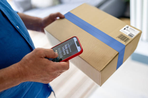 istock Man rating his delivery experience after getting a parcel at home 1421456335