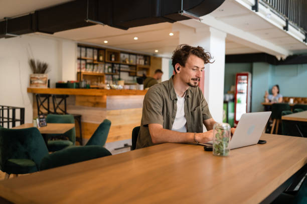 istock One young adult caucasian man work remote from cafe on laptop computer 1421458039