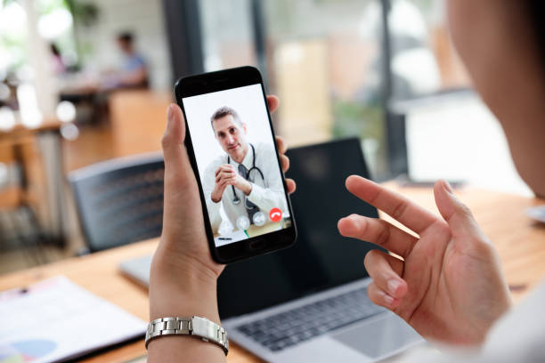 Businesswoman talking with doctor online from office. Businesswoman talking with doctor online from office. Medical specialist consulting  patient on mobile phone. Healthcare and medical concept. telemedicine stock pictures, royalty-free photos & images