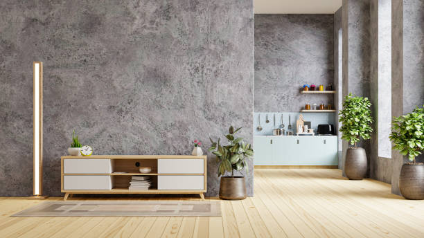Concrete room interior in warm tones with cabinet for tv which is front the kitchen.