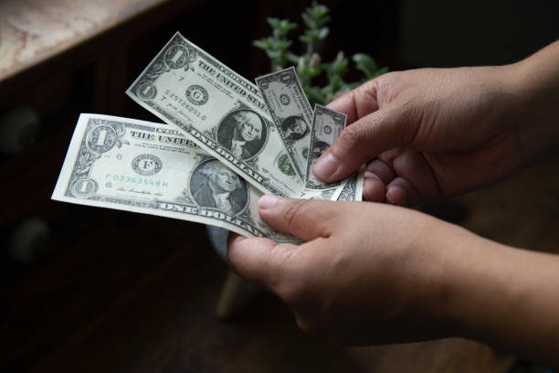 istock Hands holding shrinking dollar bills, inflation concept 1421462243