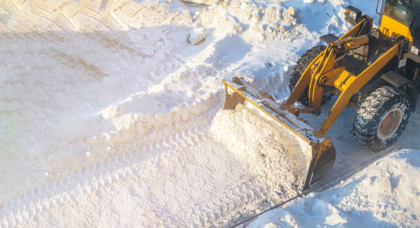 duży pomarańczowy ciągnik usuwa śnieg z drogi i oczyszcza chodnik - clear sky construction vehicle bulldozer commercial land vehicle zdjęcia i obrazy z banku zdjęć
