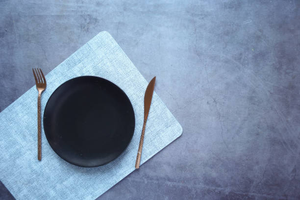 istock cutlery and empty plate on wooden background top down 1421465593