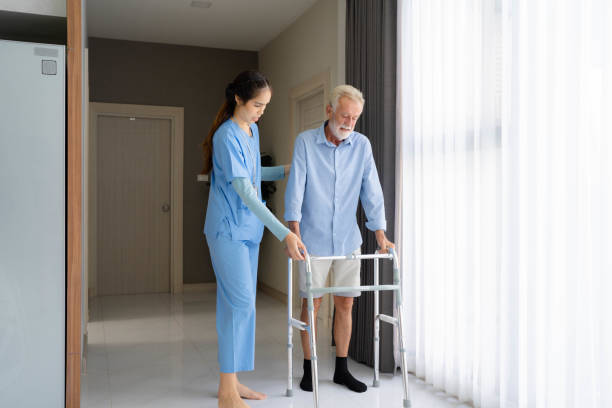 istock senior elderly man patient doing physical therapy with caregiver. 1421468036