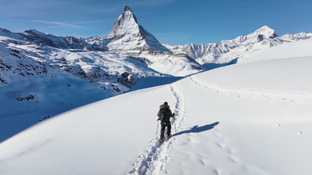Young man tourist travel hiker walking to mountain top. swiss alps, Switzerland.