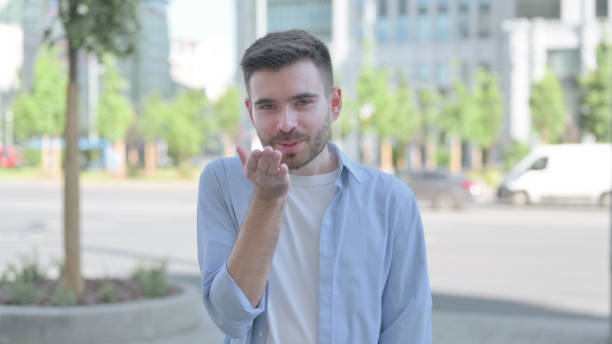 istock Loving Young Man Giving Flying Kiss by Hands 1421477593