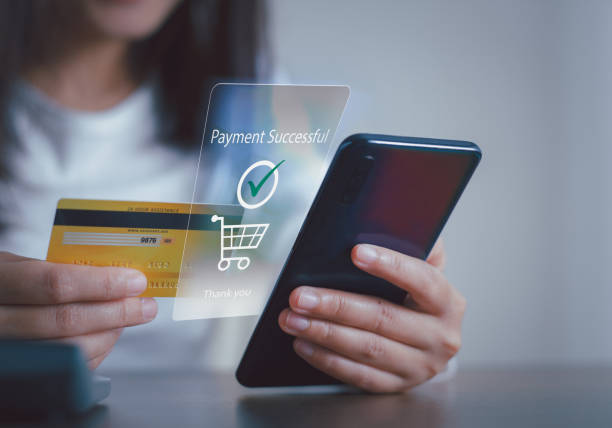 istock Female holding credit card and using mobile smart phone for online payment successful on virtual screen, Concept banking and online shopping mobile payment. 1421482401