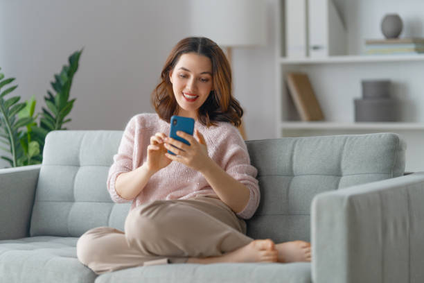 istock woman is using a phone sitting on a sofa 1421483723