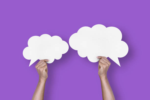 istock hand holding white paper cloud shape speech bubble balloon isolated on purple background communication bubbles 1421483988