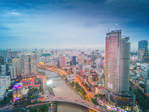 Ho Chi Minh city, Vietnam - 26 August 2022: Aerial view of Bitexco and IFC One Saigon Tower, buildings, roads, Thu Thiem 2 bridge and Saigon river - Far away is Landmark 81 skyscraper.