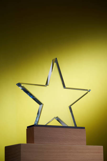 istock crystal trophy with star shape design against yellow background 1421487047