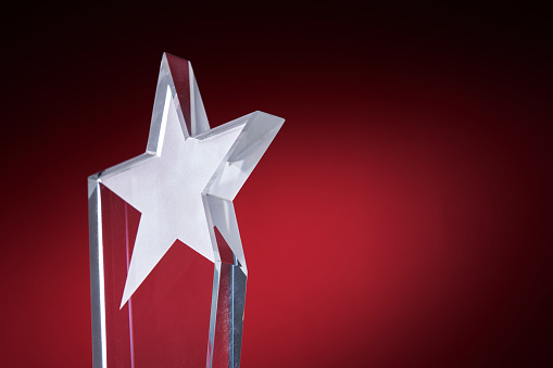 star shape crystal trophy against red background