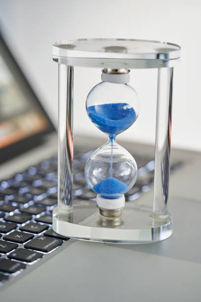 istock hour glass and laptop selective focus 1421487109