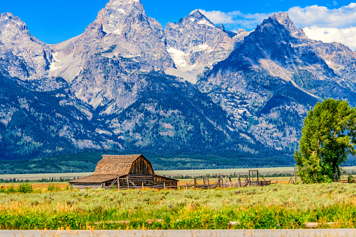 The John Moulton Barn, a publicly owned national landmark along the Mormon Row Historic District in Grand Teton National Park, Wyoming with the peaks of the Teton Range in the background.  This barn is known as the \