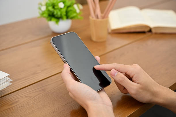 istock A man using a smartphone at his desk, touching on screen, phone black screen. 1421488467