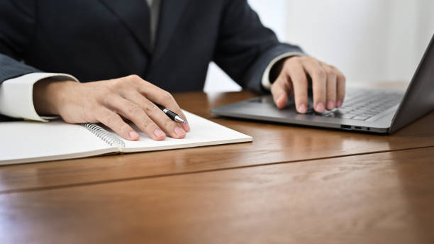 istock cropped, Successful businessman in formal suit working at his desk, using laptop computer. 1421488662