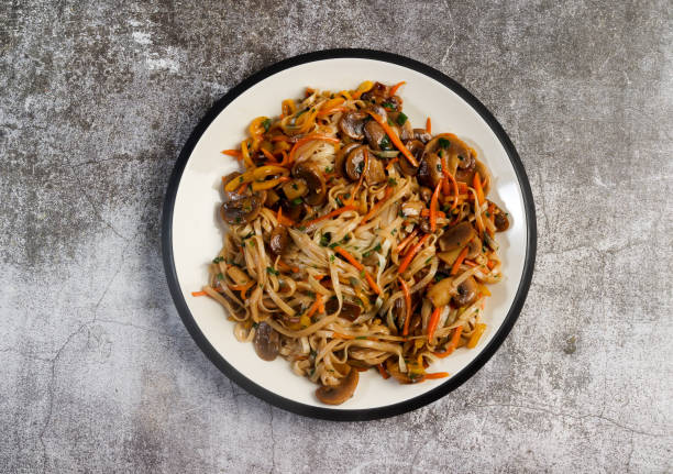 vegetarian lo mein noodles on a round plate on a dark background. top view, flat lay - bean vegetarian food stir fried carrot imagens e fotografias de stock