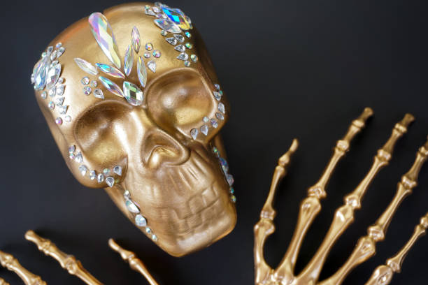 istock On a black background, a golden skeleton skull decorated with rhinestones 1421497735