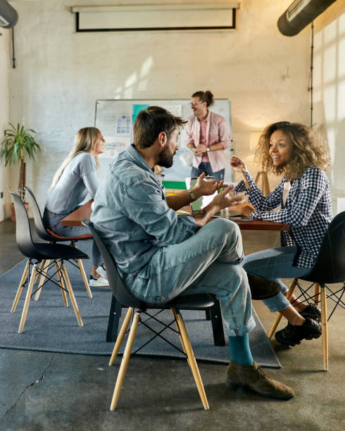 istock Happy freelancers talking while having a casual meeting in the office. 1421499499
