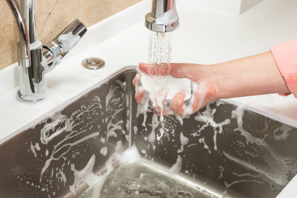 istock Sponge in a woman's hand is washed off with tap water 1421501029
