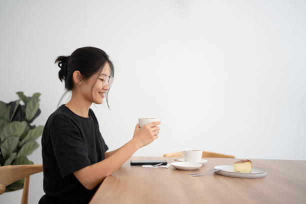 istock Young Asian lady enjoying coffee in cafe 1421509528