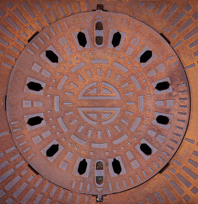 Berlin, March 29, 2014 - Sewer cover of the Berliner Wasserbetriebe in Berlin with the principal buildings of the city.