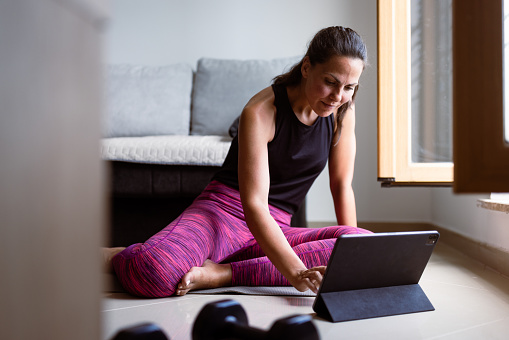 Woman working out at home with a online coach