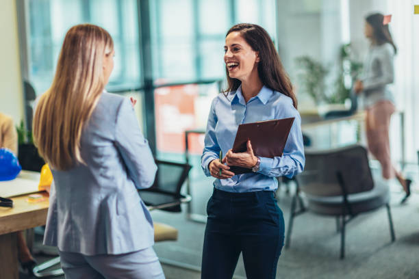 istock Two businesswomen talking in the office 1421513048