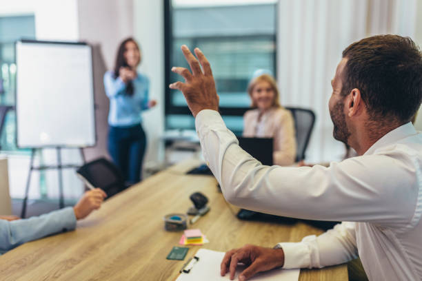 hombre de negocios levantando la mano para hacer la pregunta en un seminario en la sala de juntas. - seminar asking business meeting fotografías e imágenes de stock