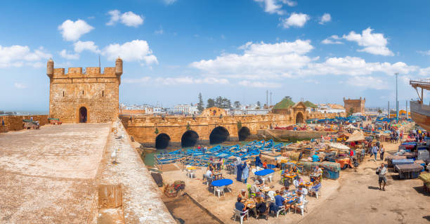 People eating street food in old fishing port Essaouira, Morocco Essaouira, Morocco - April  28, 2019:
People eating street food in old fishing port Essaouira, Morocco essaouira stock pictures, royalty-free photos & images