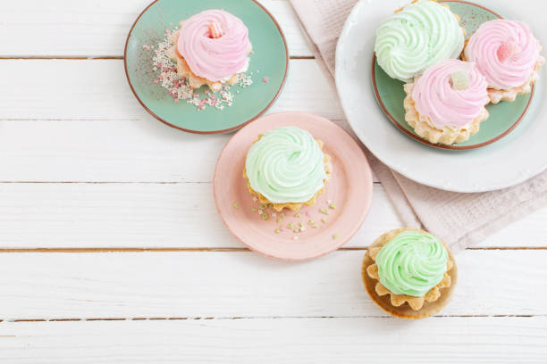 istock cupcakes on plates on white wooden background 1421519738