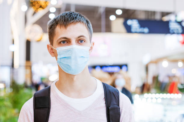 istock guy in a protective mask with a backpack in the mall 1421521014