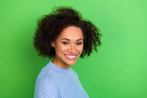 istock Portrait of young beautiful cute nice girl with perming coiffure dressed blue pullover smile on camera isolated on green color background 1421521103