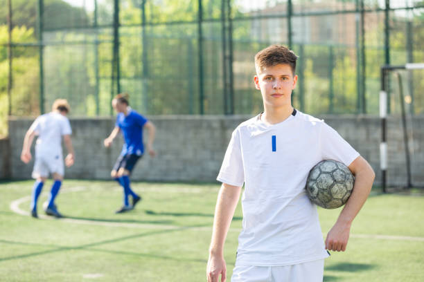 istock Young football player standing on pitch 1421522077
