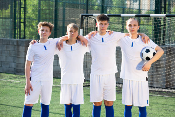 istock Young football team standing on pitch 1421522110