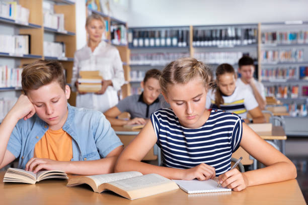istock Schoolgirl writing lesson in classroom 1421525364