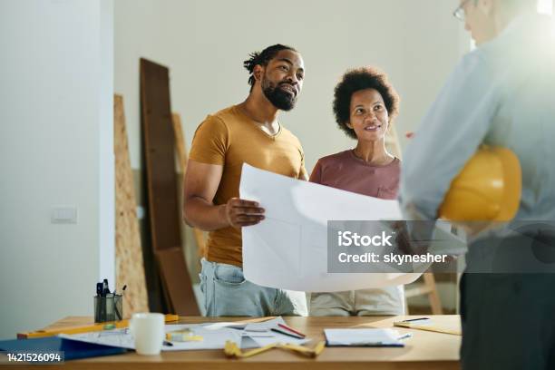 Happy Black Couple Talking To Real Estate Agent In The Apartment Stock Photo - Download Image Now