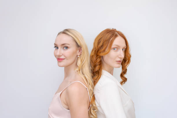 porträt zwei fröhliche blonde und rothaarige frauen in sommerkleidung lächelnd, posierend - lipstick russian ethnicity fashion model fashion stock-fotos und bilder