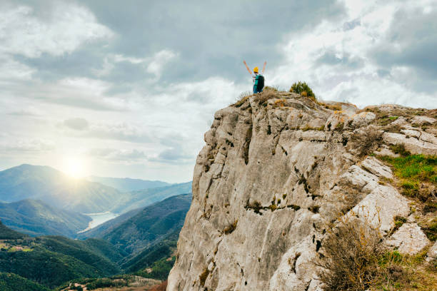 istock Young woman with backpack at top of mountain 1421530506